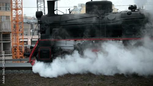 steam train in clouds of smoke passes by photo