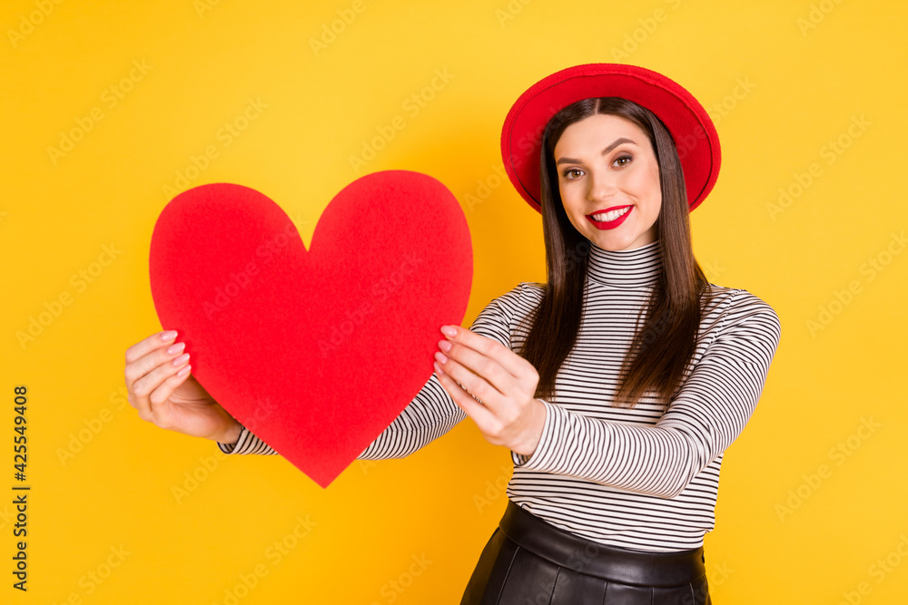 Photo of young cheerful girl happy smile hold big red heart valentine day love isolated over yellow color background Photo of young cheerful girl happy smile hold big red heart valentine day love isolated over yellow color background