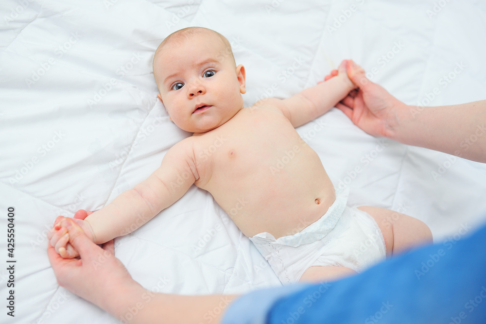 caring mother makes a baby son developing gymnastics. caring mother makes a baby son developing gymnastics.