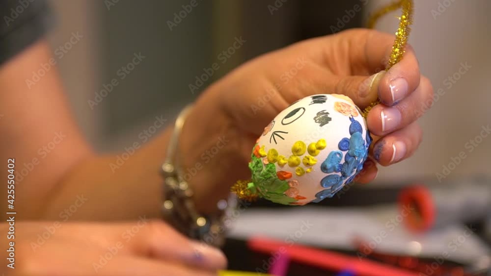 Easter egg painting and decorating activity concept: Human hands decorating colorful handmade Easter eggs. Preparation for the holidays. Stationary objects on the table. Creative indoor decoration. Easter egg painting and decorating activity concept: Human hands decorating colorful handmade Easter eggs. Preparation for the holidays. Stationary objects on the table. Creative indoor decoration.