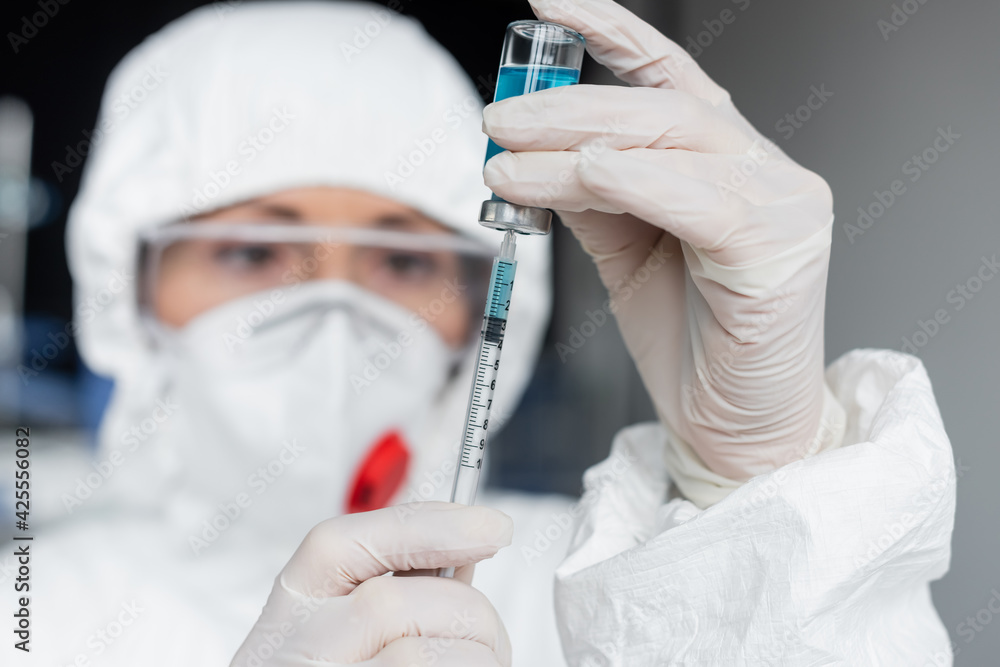 Scientist on blurred background picking up vaccine in syringe - obrazy, fototapety, plakaty 