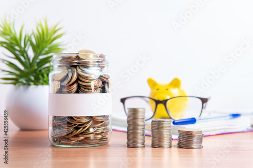 The coins are stored in a glass jar to accumulate finances.