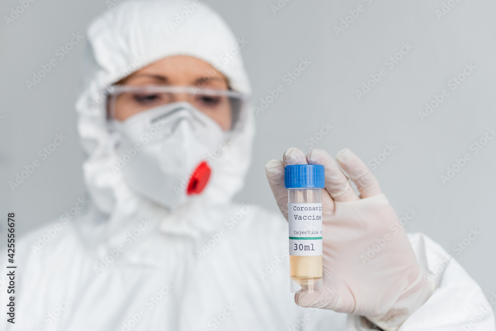 Coronavirus vaccine in hand of scientist in protective uniform blurred on background Coronavirus vaccine in hand of scientist in protective uniform blurred on background