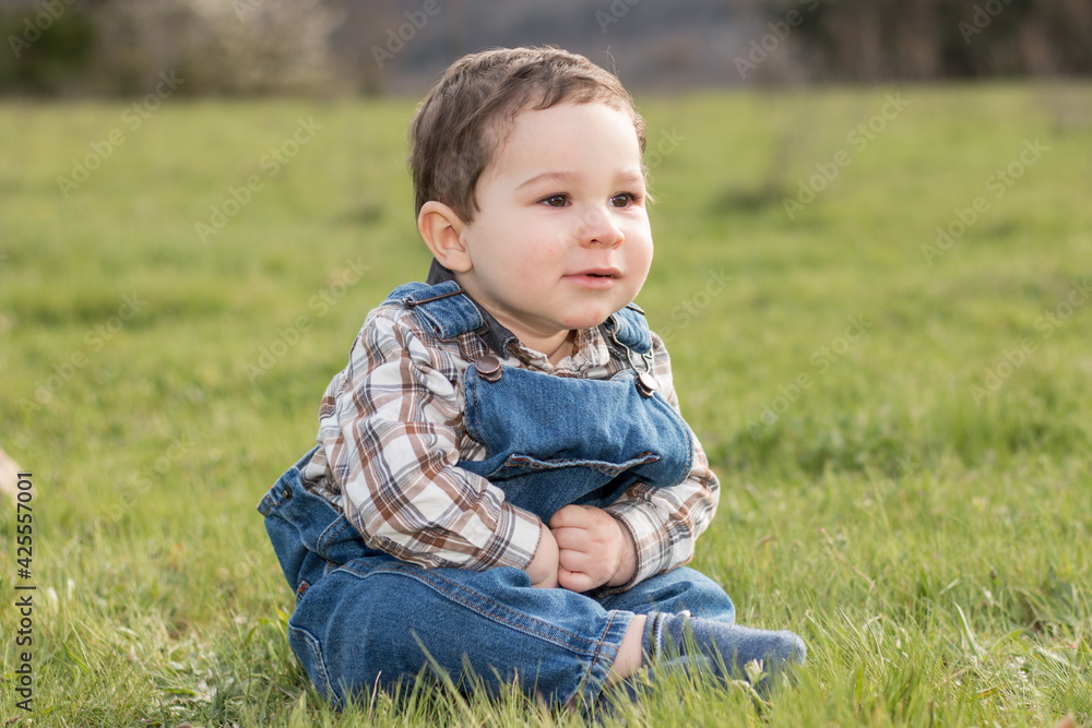baby sitting on the grass with denim clothes baby sitting on the grass with denim clothes