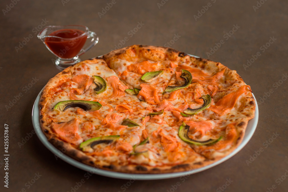 Pizza with salmon and avocado on a plate