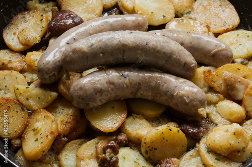 Recette traditionnelle du sud ouest, saucisses confites et pommes de terre à la façon sarladaise, de la ville de Sarlat en Dordogne, recette typique et gouteuse