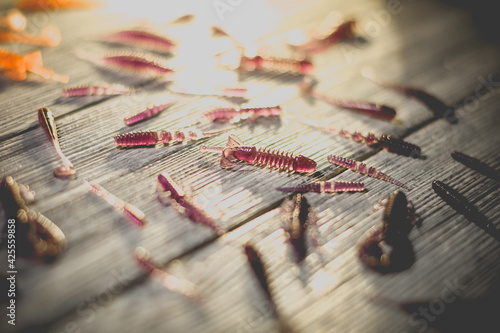 Nice view of fishing silicone baits on a wooden background. Studio photo.