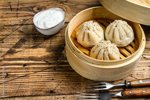 Asian steamed dumplings Manti in a bamboo steamer. Wooden background. Top view. Copy space