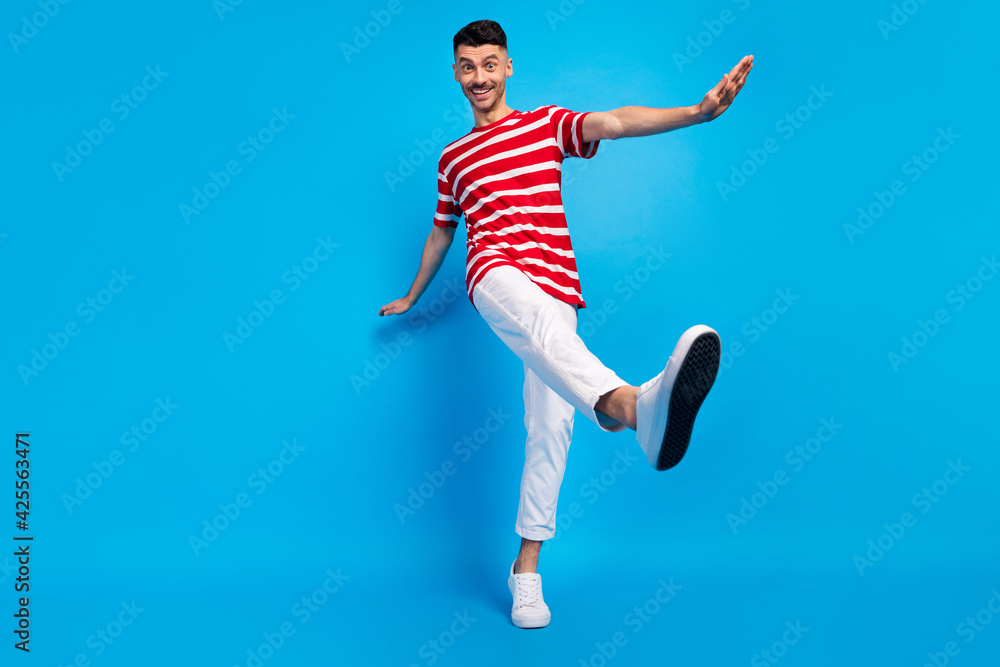 Low angle view full size photo of cheerful young man dance good mood isolated on blue color background