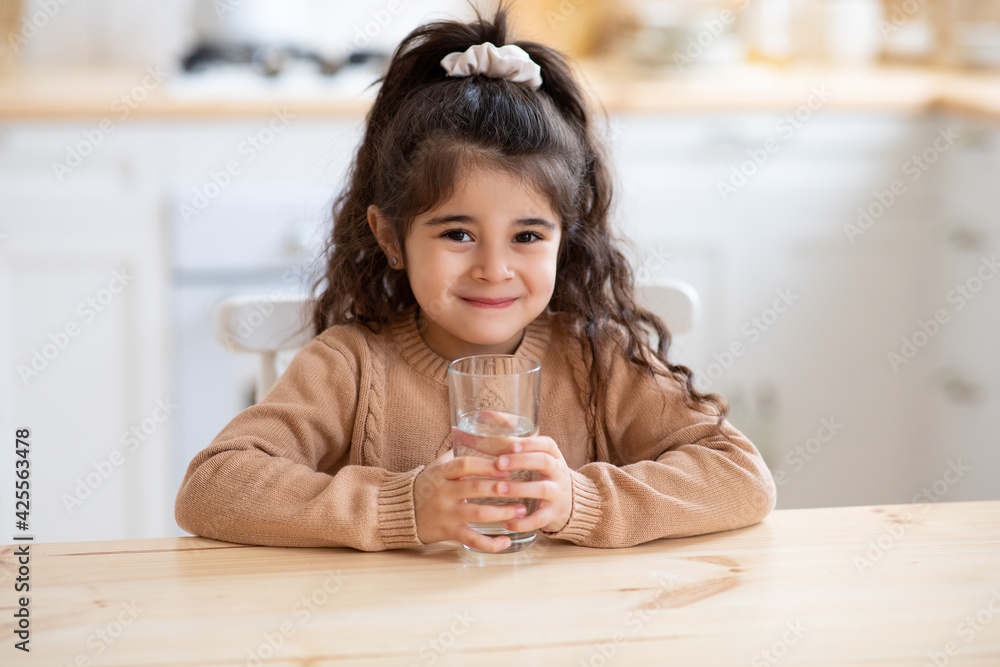 Pretty Little Arab Preschool Girl Drinking Water In Kitchen At Home Pretty Little Arab Preschool Girl Drinking Water In Kitchen At Home