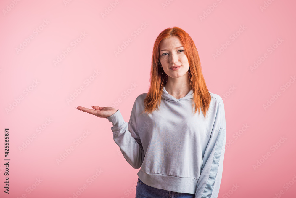 Redhead girl holding hand copyspace in studio on pink background Redhead girl holding hand copyspace in studio on pink background