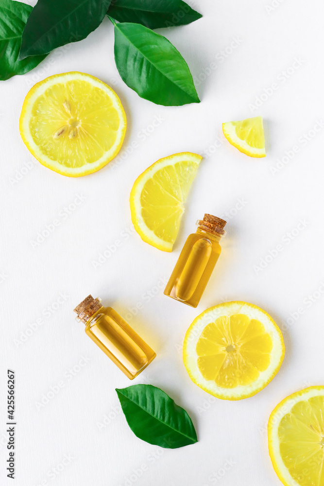 Citrus oil and lemon slices on a white wooden background. view from above. Natural oils for use in medicine, spa, aromatherapy. Citrus oil and lemon slices on a white wooden background. view from above. Natural oils for use in medicine, spa, aromatherapy.