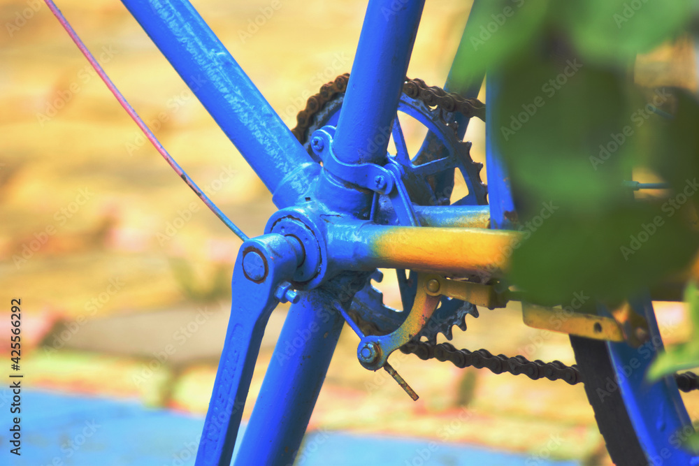 close up of a chain. repainted old bicycle with blue and yellow color
