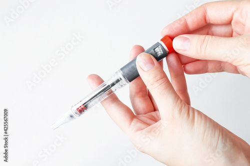 The person holds the insulin pen for the injection and sets the dose of the medication. Diabetic life, health monitoring.