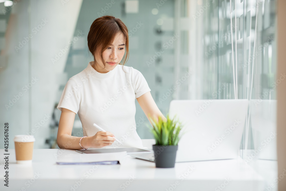 Asian Young Woman working on laptop. Freelancer at remote work. Female student learning on-line via computer. Blogger or journalist writing new article. Asian Young Woman working on laptop. Freelancer at remote work. Female student learning on-line via computer. Blogger or journalist writing new article.