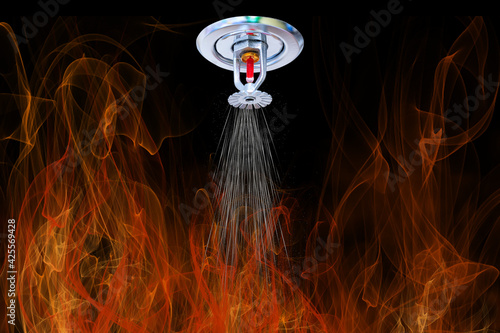 Automatic fire extinguishing system. Fire Sprinkler spraying. Fire and water on background.