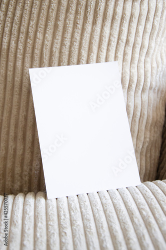 Greeting card, postcard, invitation mock up on cozy apparel background in interior. Flat lay.