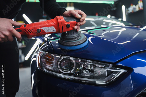 Man in a mask polishes car