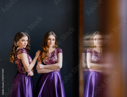Front view of two beautiful girlfriends in purple dresses posing and looking at the camera. Сoncept of beautiful dresses © IVASHstudio
