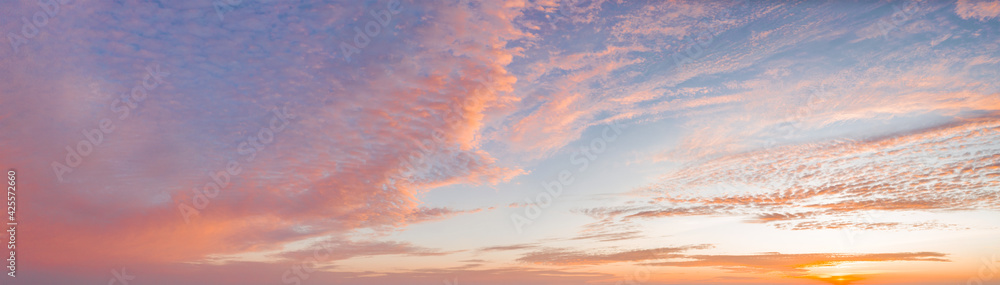 Fototapeta premium intense dramatic panoramic sunset with cirrus clouds illuminated by red sunbeams