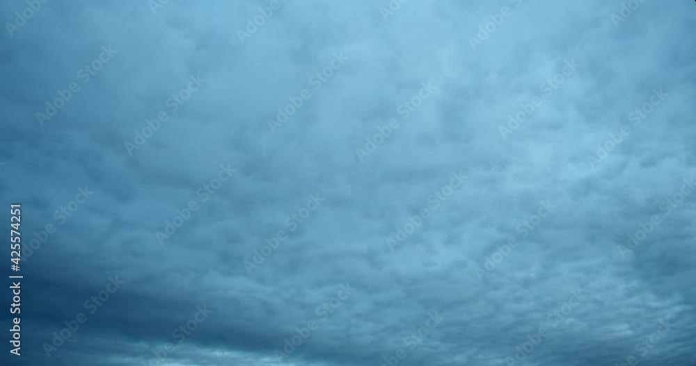 A solid continuous stream of curly clouds in the sky. Abstract blue textured backdrop. A solid continuous stream of curly clouds in the sky. Abstract blue textured backdrop.