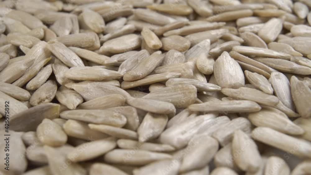 Peeled sunflower kernels rotate in close-up. Healthy raw seeds. Macro shot Peeled sunflower kernels rotate in close-up. Healthy raw seeds. Macro shot