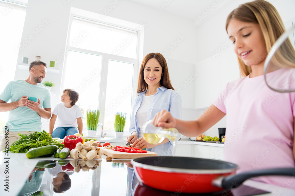 Photo of happy positive smiling family cooking together mother teach daughter making breakfast father and song relaxing at home