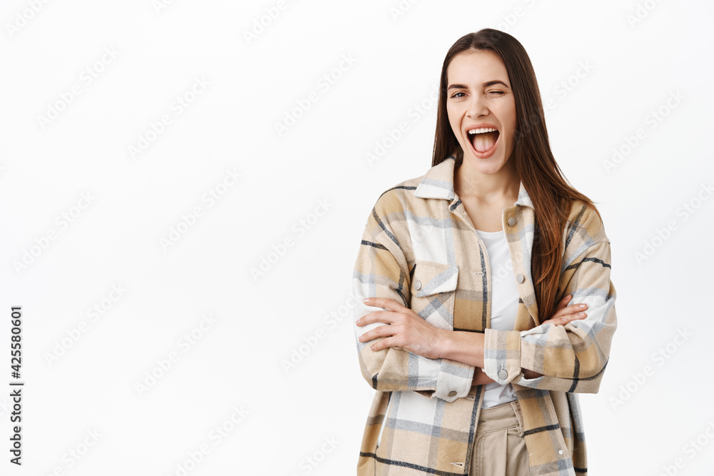 Happy beautiful woman winking and smiling, assure all is good, encourage you, give her support or hinting on good promo deal, standing in stylish clothes against white background Happy beautiful woman winking and smiling, assure all is good, encourage you, give her support or hinting on good promo deal, standing in stylish clothes against white background
