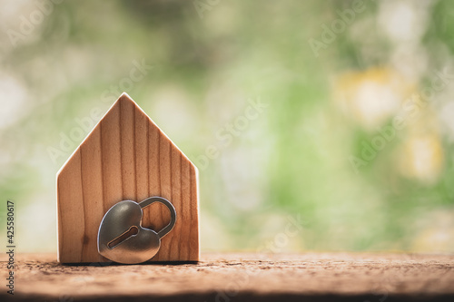 House model and heart shaped key put on the coin with growing interest value on sunlight in the public park, Saving money or loan for business investment real estate or buy a home for family concept.