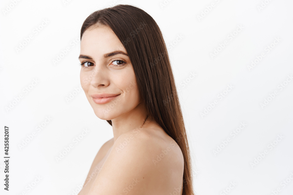 Beautiful woman face cosmetic concept, healthy natural clean skin nude make up, facial without wrinkles, hydrated and smooth, long perfect hair strands on naked back, smiling at camera Beautiful woman face cosmetic concept, healthy natural clean skin nude make up, facial without wrinkles, hydrated and smooth, long perfect hair strands on naked back, smiling at camera