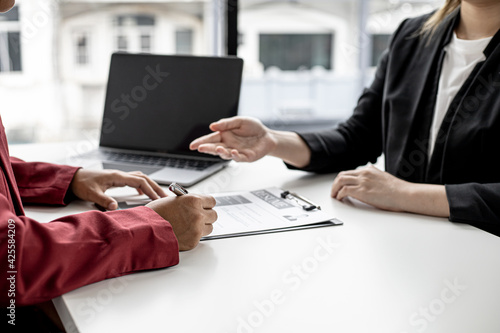 The job applicant is attending a job interview with the department manager and is introducing himself and explaining the information in the resume to the manager in order to be elected to the company.