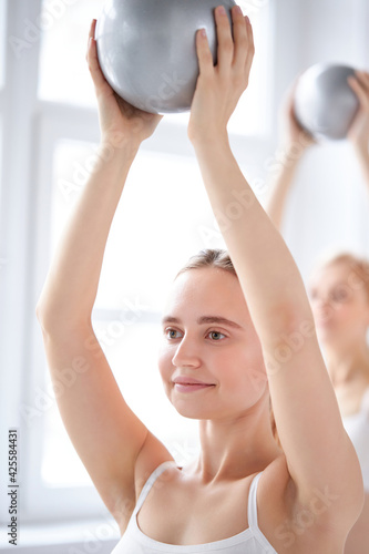 caucasian woman training with balls with group of pther women photo