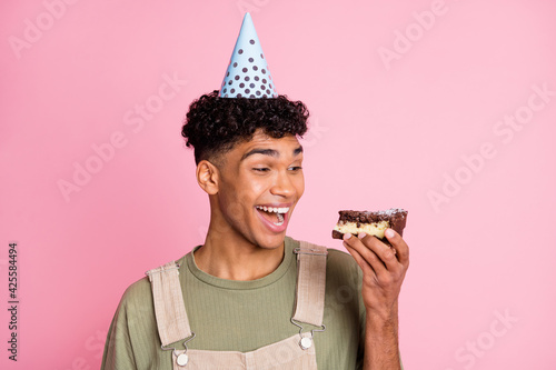 Canvas Print Photo portrait of curly boy eating birthday cake smiling wearing festive cone ov
