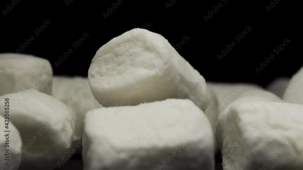 white marshmallow rotating on a black background, a handful of marshmallows. close-up. white marshmallow rotating on a black background, a handful of marshmallows. close-up.