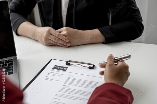 The HR department is reviewing the applicant's resume before giving them an interview with the department manager. The concept of recruiting people to work in the company.