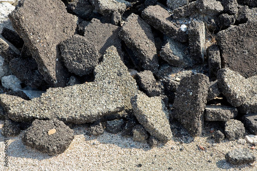 Cracked asphalt pieces after demolition of a road surface in a construction site for renovation ready to be recycled photo