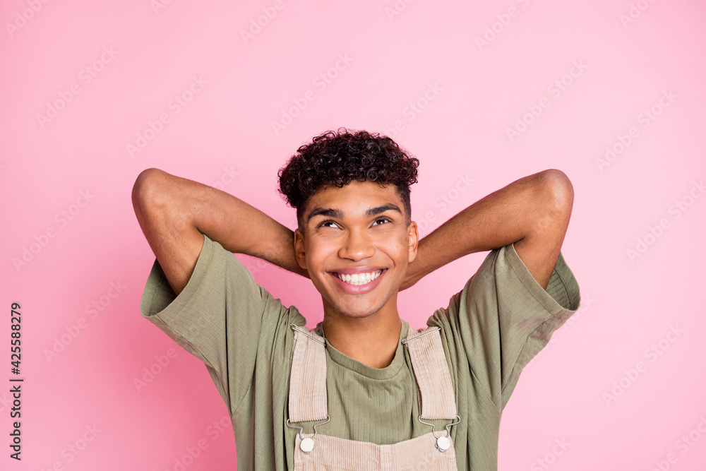 Photo of positive guy look up empty space dream relax wear beige overall isolated pink color background Photo of positive guy look up empty space dream relax wear beige overall isolated pink color background