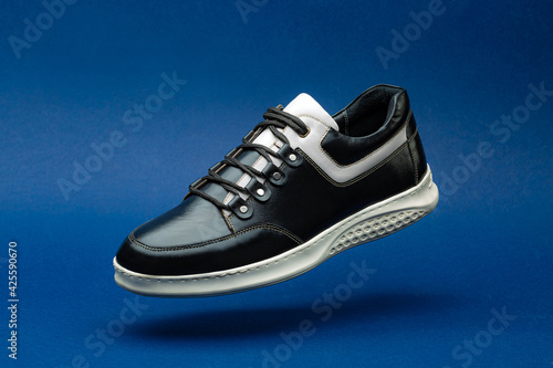 Black and white leather shoe on blue background