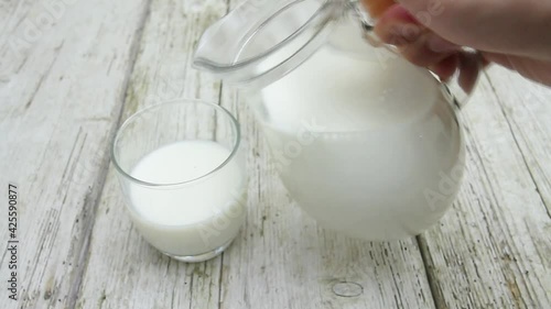 broc de lait remplissant un verre sur une table photo