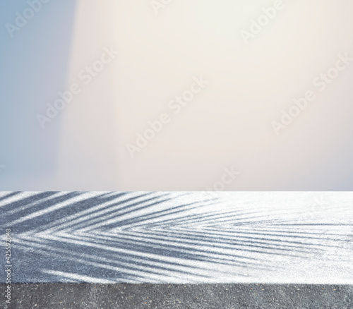 Concrete table counter with blur  shadow of coconut leaf on pastel background.