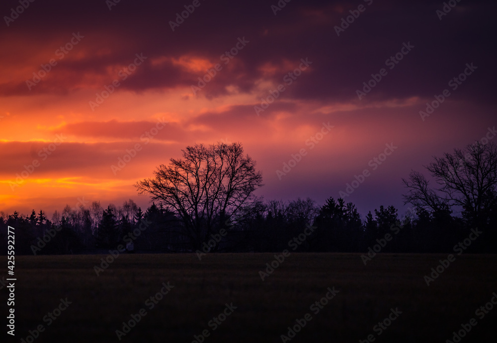 Beautiful clouds over the springtime scenery during the sunrise. Dramatic, colorful look. Rural landscape of Northern Europe.