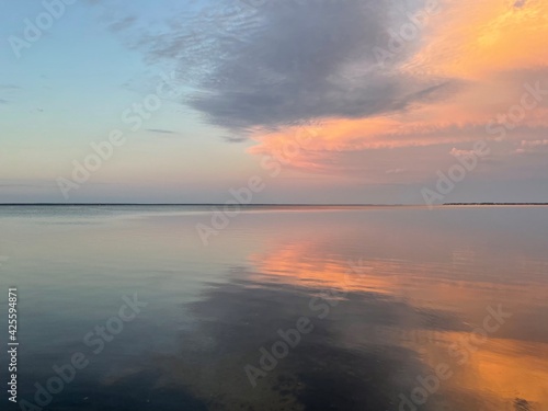 sunset over the bay with cloud reflections onto water  © Gerri