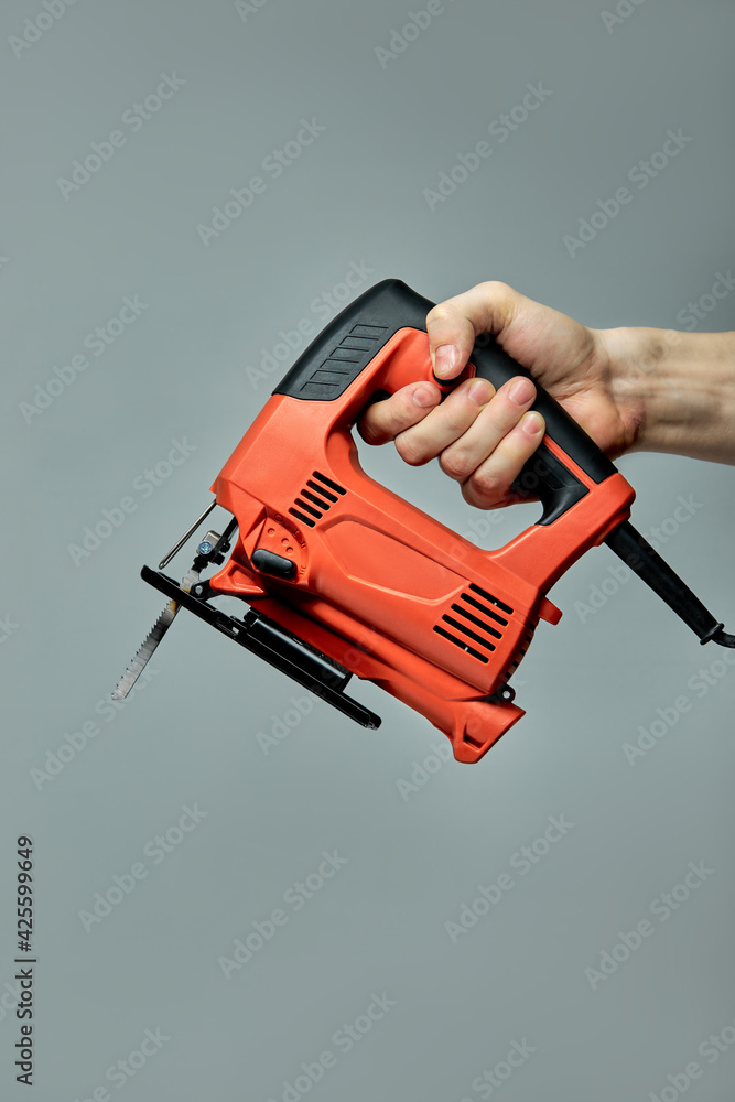 Professional Red Electric Jig Saw isolated On Gray Background Professional Red Electric Jig Saw isolated On Gray Background