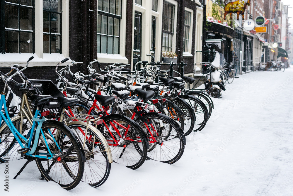 Bicycles parked at the house on a snowy street. Amsterdam, Netherlands. Bicycles parked at the house on a snowy street. Amsterdam, Netherlands.