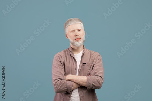 Foto Young albino man posing with crossed arms and looking with serious face expressi
