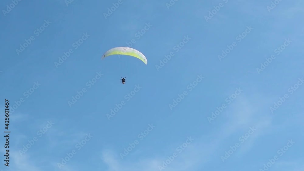 Paraglider approaching over a blue sky. Paraglider approaching over a blue sky.