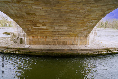 Stone bridge in Regensburg over the Danube with cathedral and Bruck Mandl