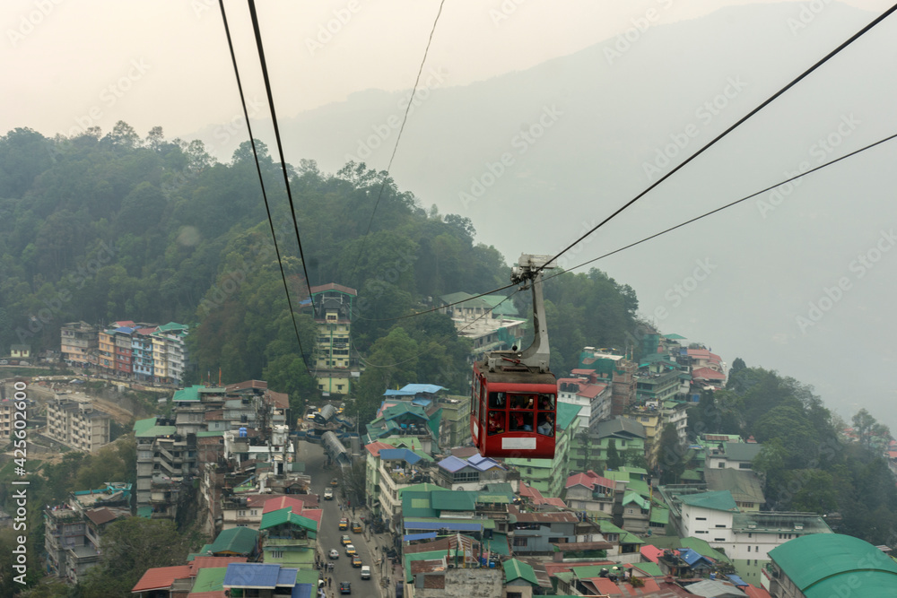28th March, 2021, Gangtok, Sikkim, India: Tourists enjoying a rope way cable car or Gondola ride over Gangtok city during sunset. Amazing aerial view of Sikkim