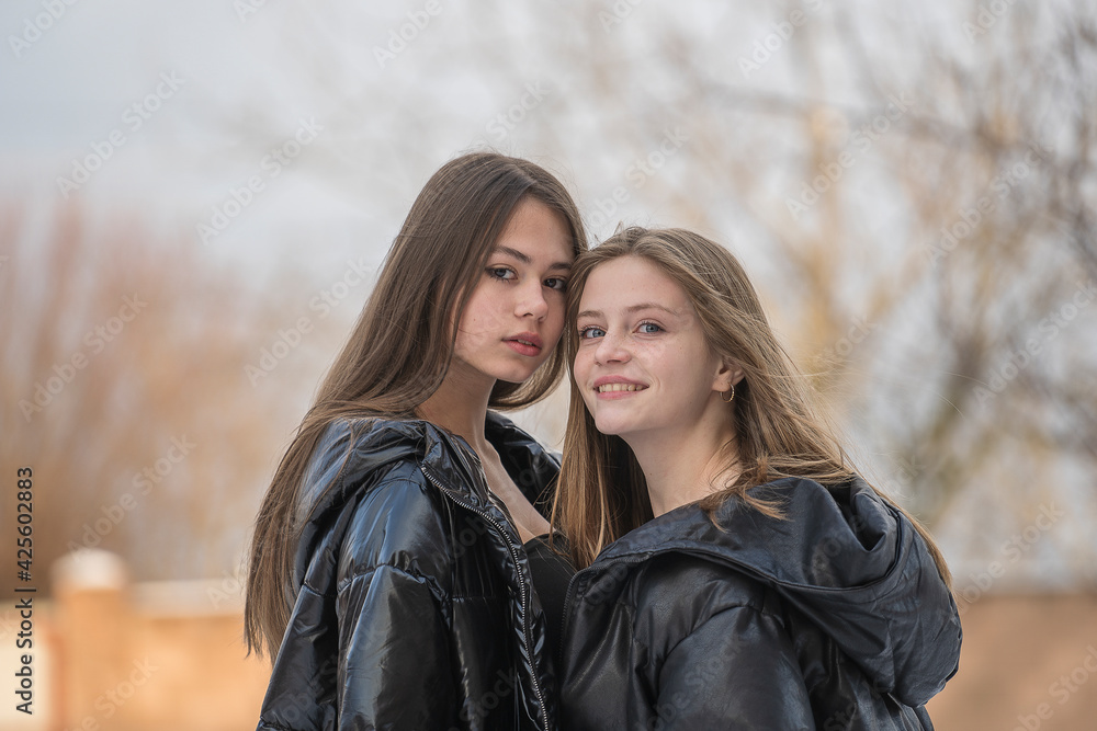 Fototapeta premium Portrait of two charming young girls, outdoors, close up