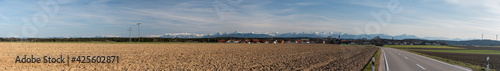 Landschaft Panorama bei Palling mit bestelltem Feld im Frühjahr, Bergen, Häuser und Strommasten photo